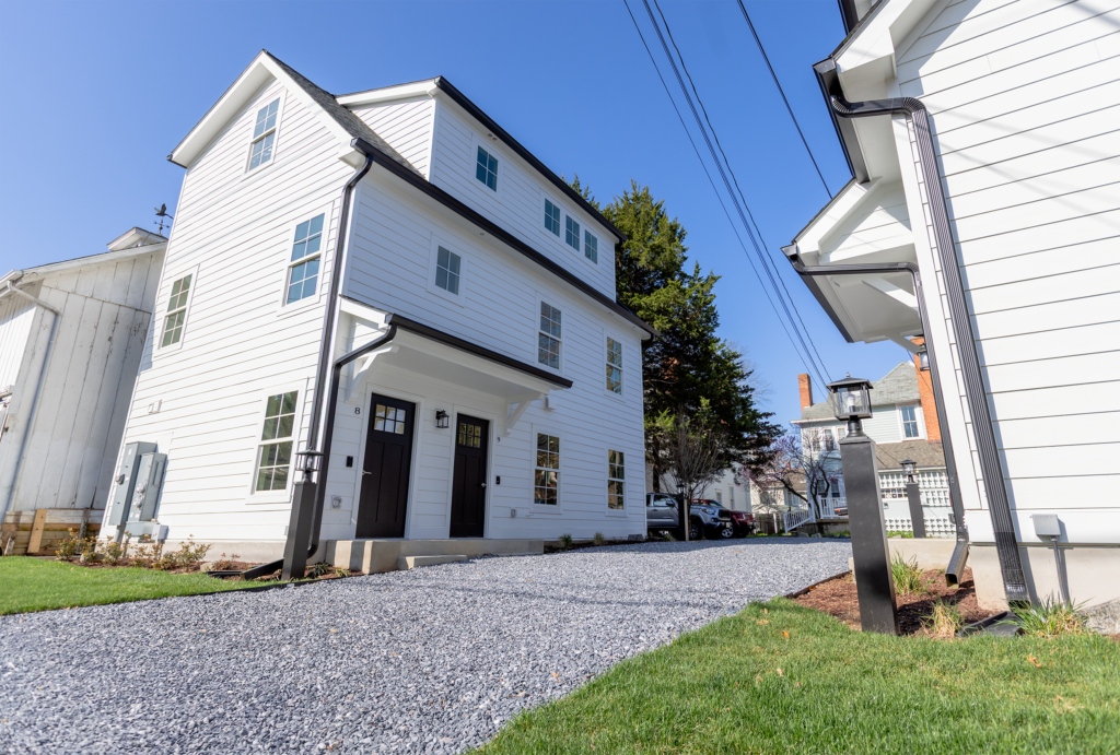 A white building two story building with black doors and black trim
